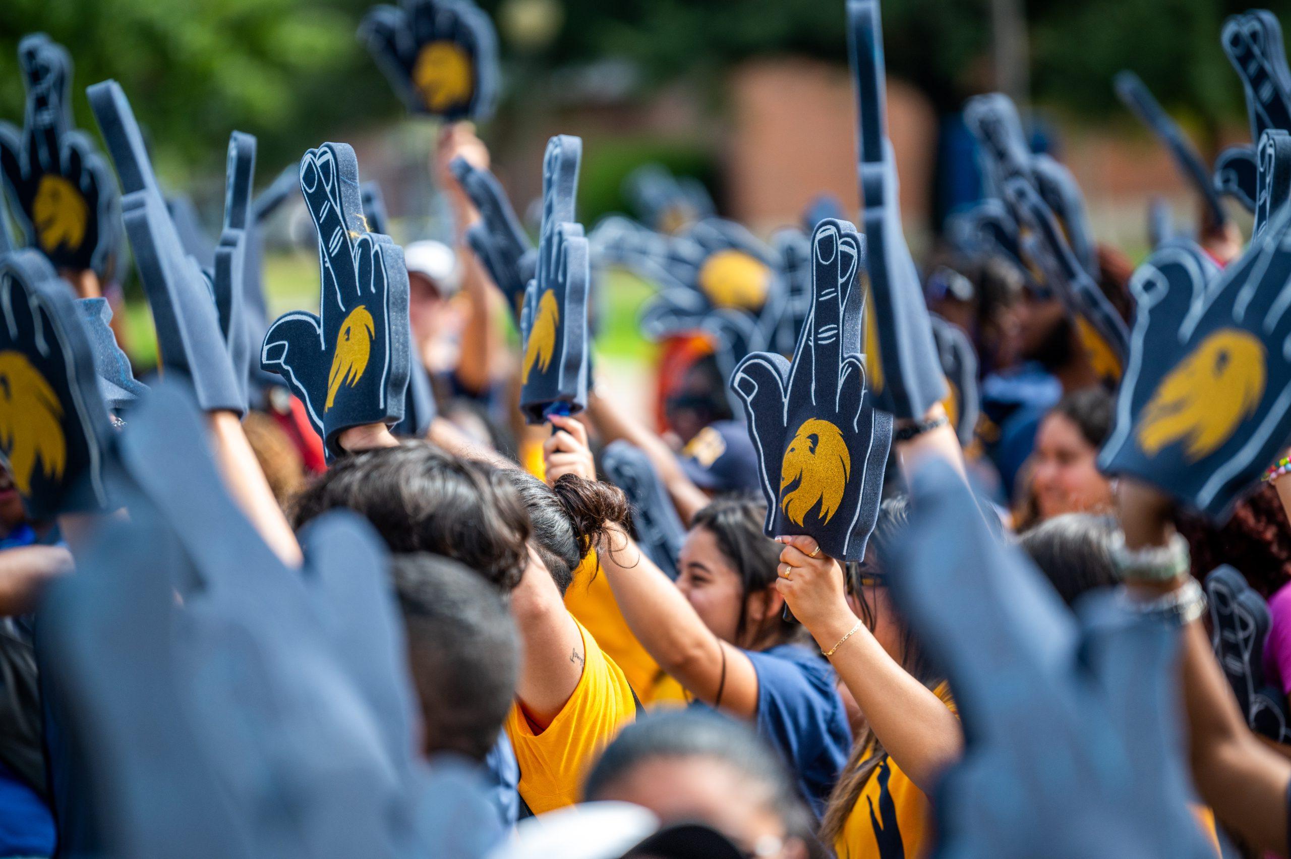 A group of students with foam finger outside.